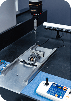 Machine à mesurer tridimensionnelle contrôlant une pièce usinée dans l'atelier de métrologie d'ARCOM Industrie