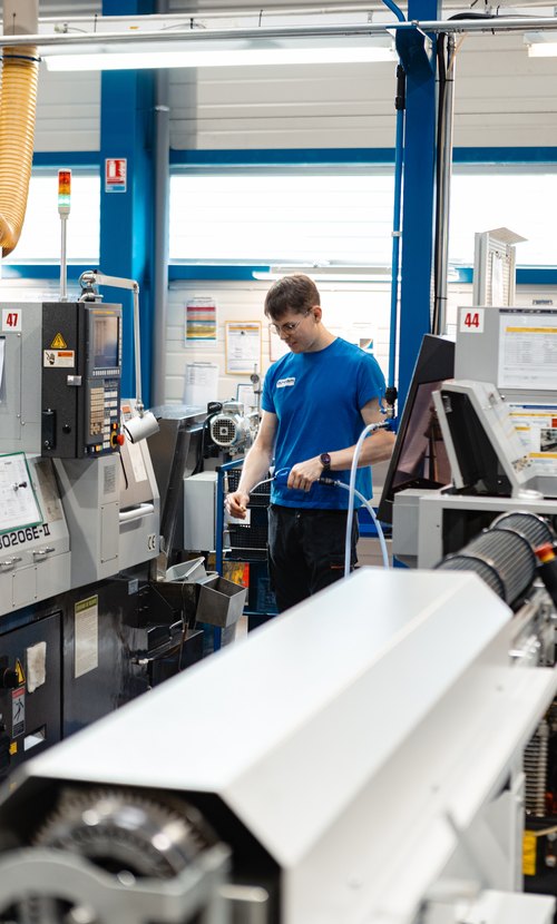Opérateur au poste d’un tour CN à poupée mobile Tsugami